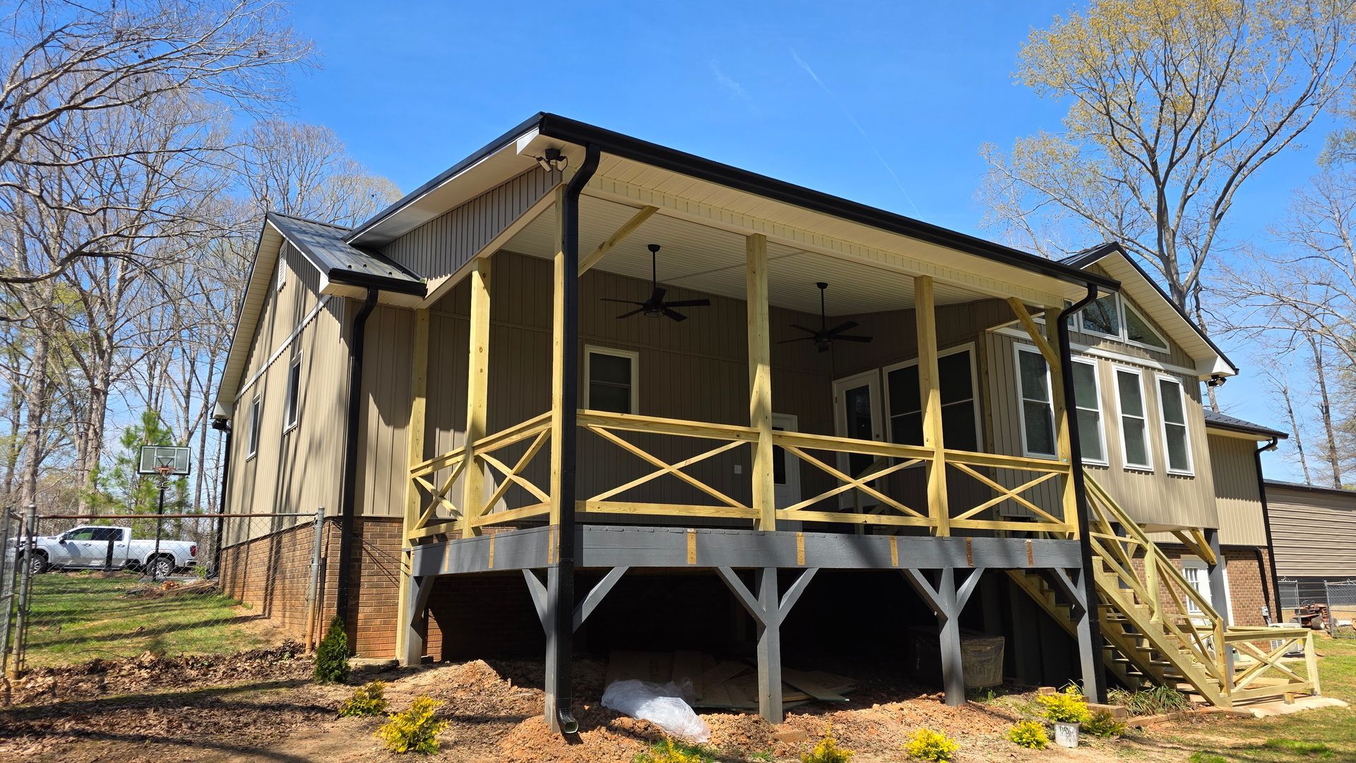 The back of a house with a large porch and stairs.