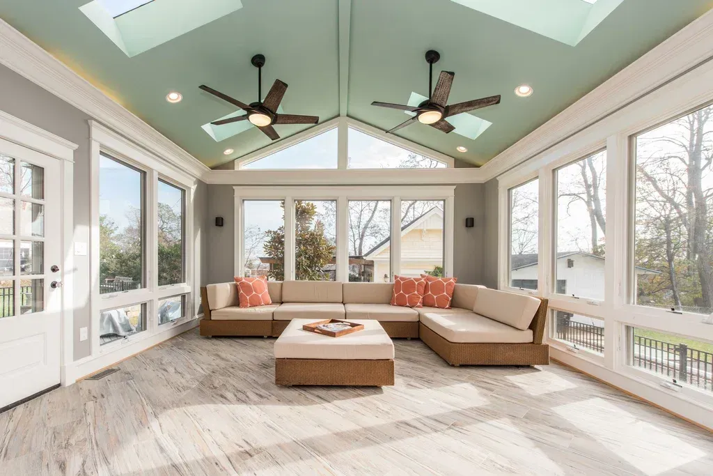 A living room with a lot of windows and a ceiling fan.