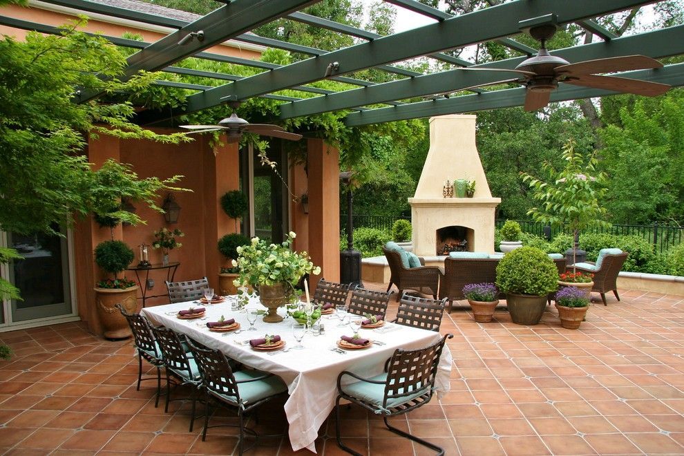 A patio with a table and chairs and a fireplace