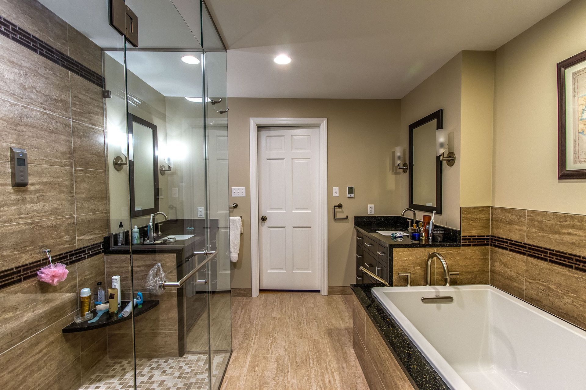 A bathroom with a tub , sink , and walk in shower.