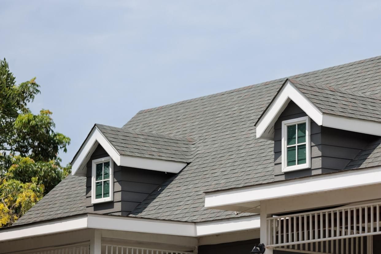 There are two windows on the roof of a house.