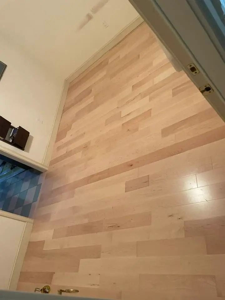 Empty room with light wood flooring and a doorway at the right.
