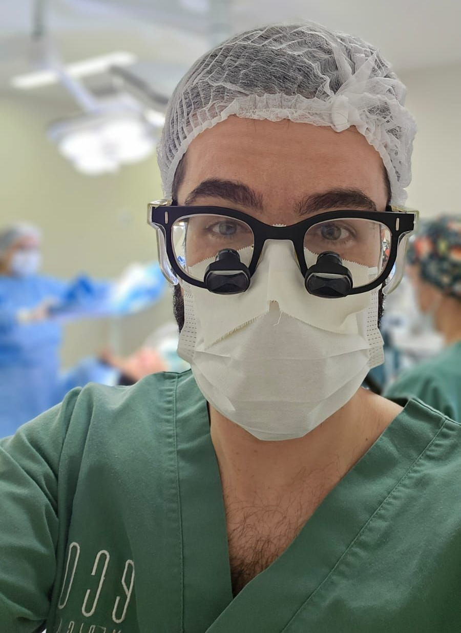 Dr. Thomas Marcolini, neurocirurgião especialista em nervos periféricos, utilizando lupas cirúrgicas para tratamento de precisão em dor de membro fantasma e neuromas.