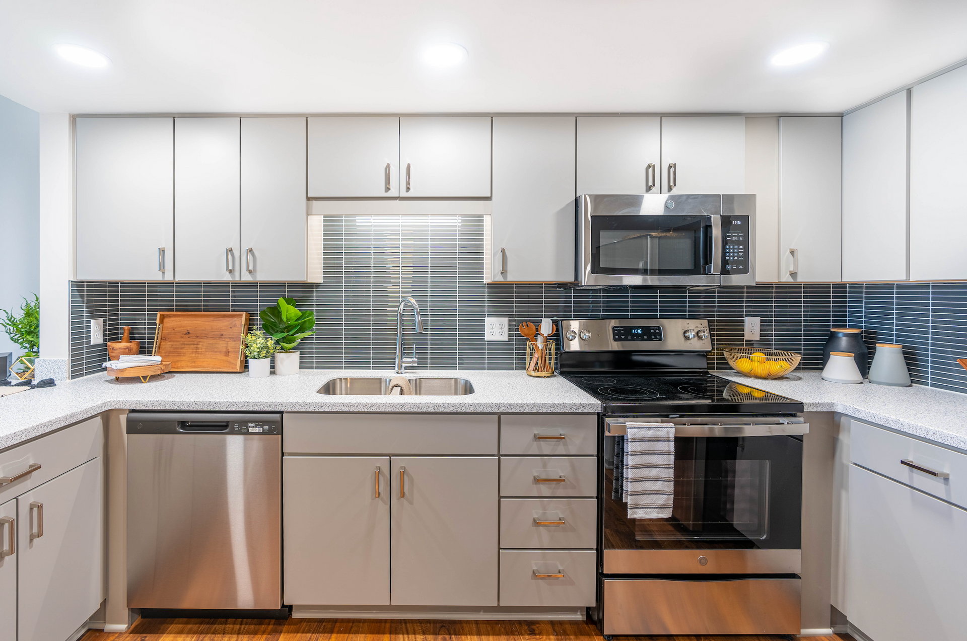 Modern kitchen with white cabinets, stainless steel appliances, and a tiled backsplash.