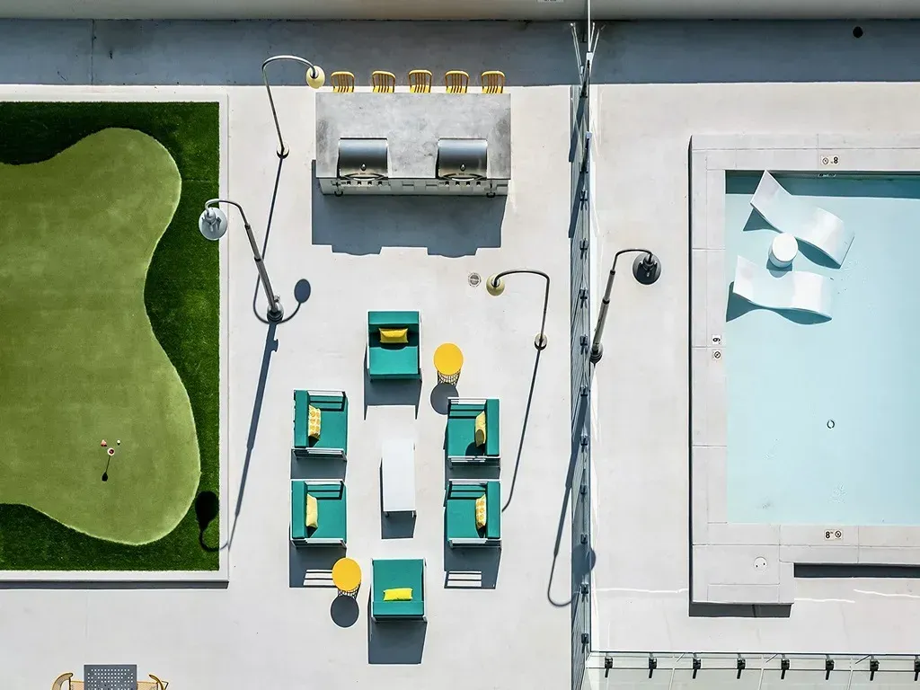 Top-down view of a small board game setup on a table with green and teal pieces and a light blue board.