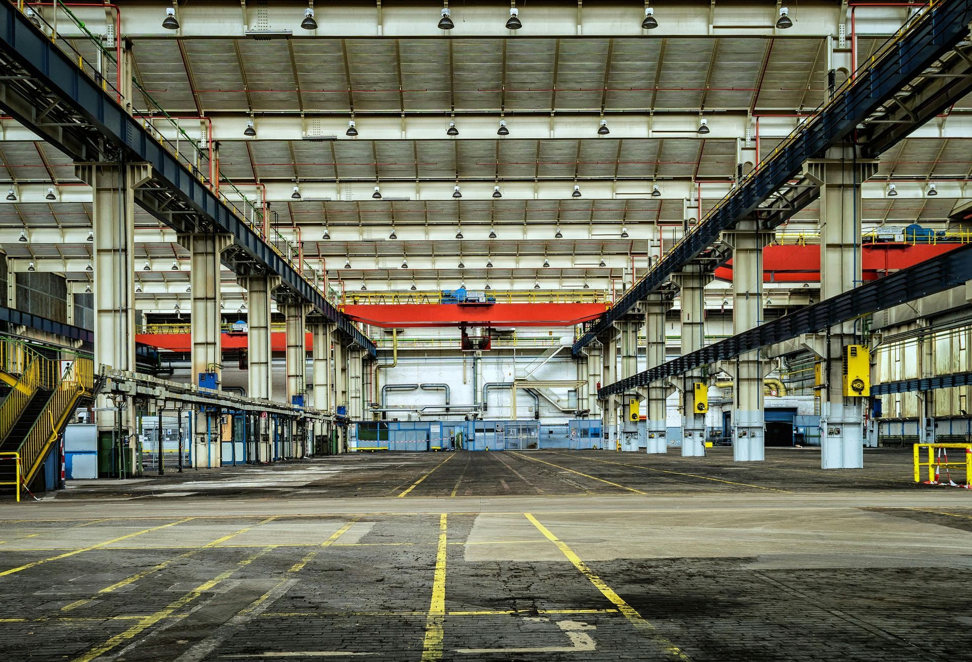 A large empty factory building with a lot of machinery in it.