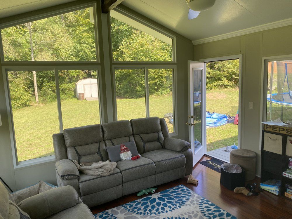 A living room with a couch , chairs , and a ceiling fan.