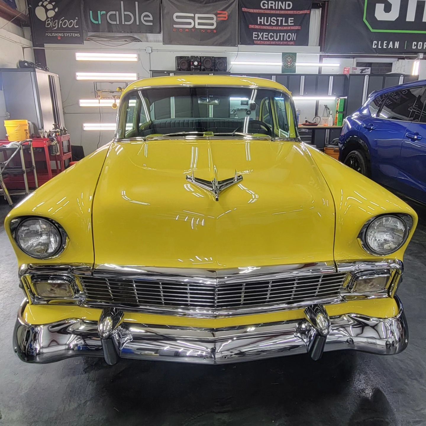 Yellow classic car with chrome details in a garage.