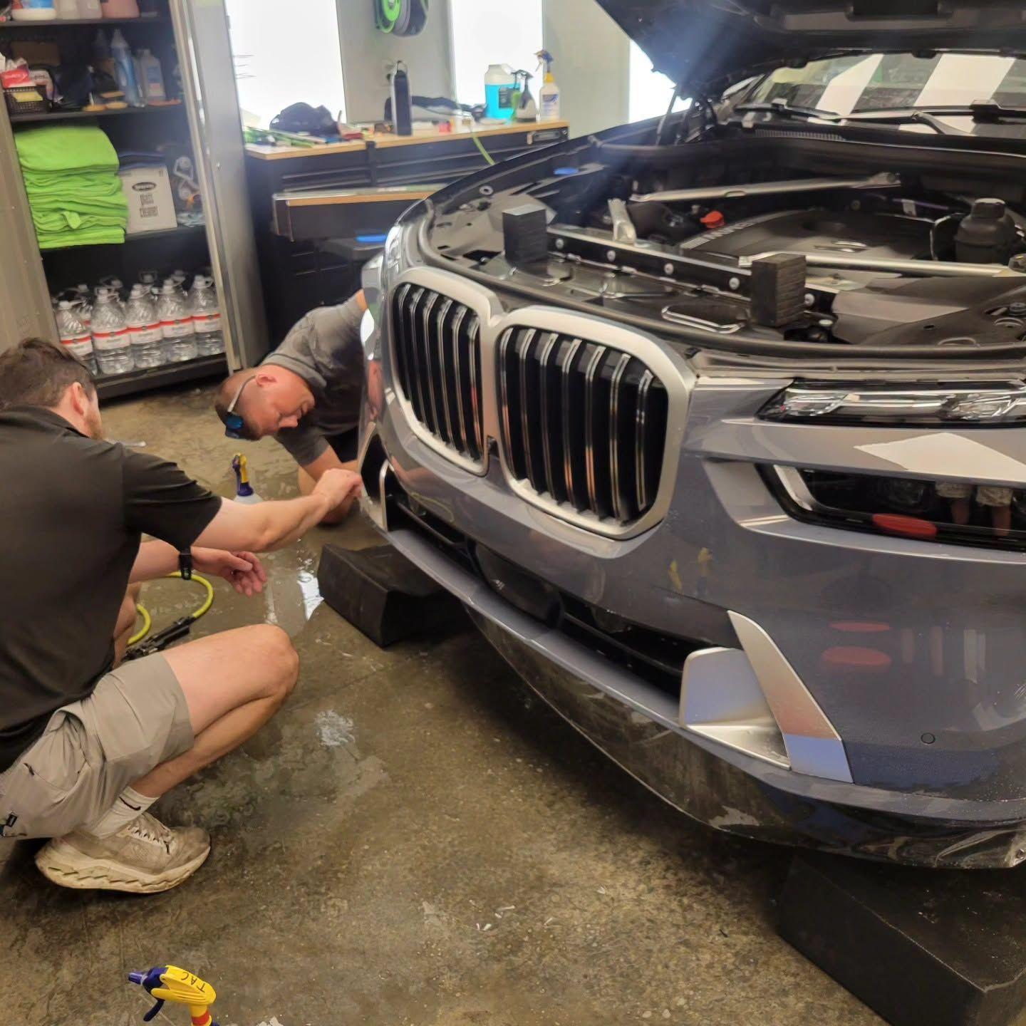 technician applying PPF to a BMW car