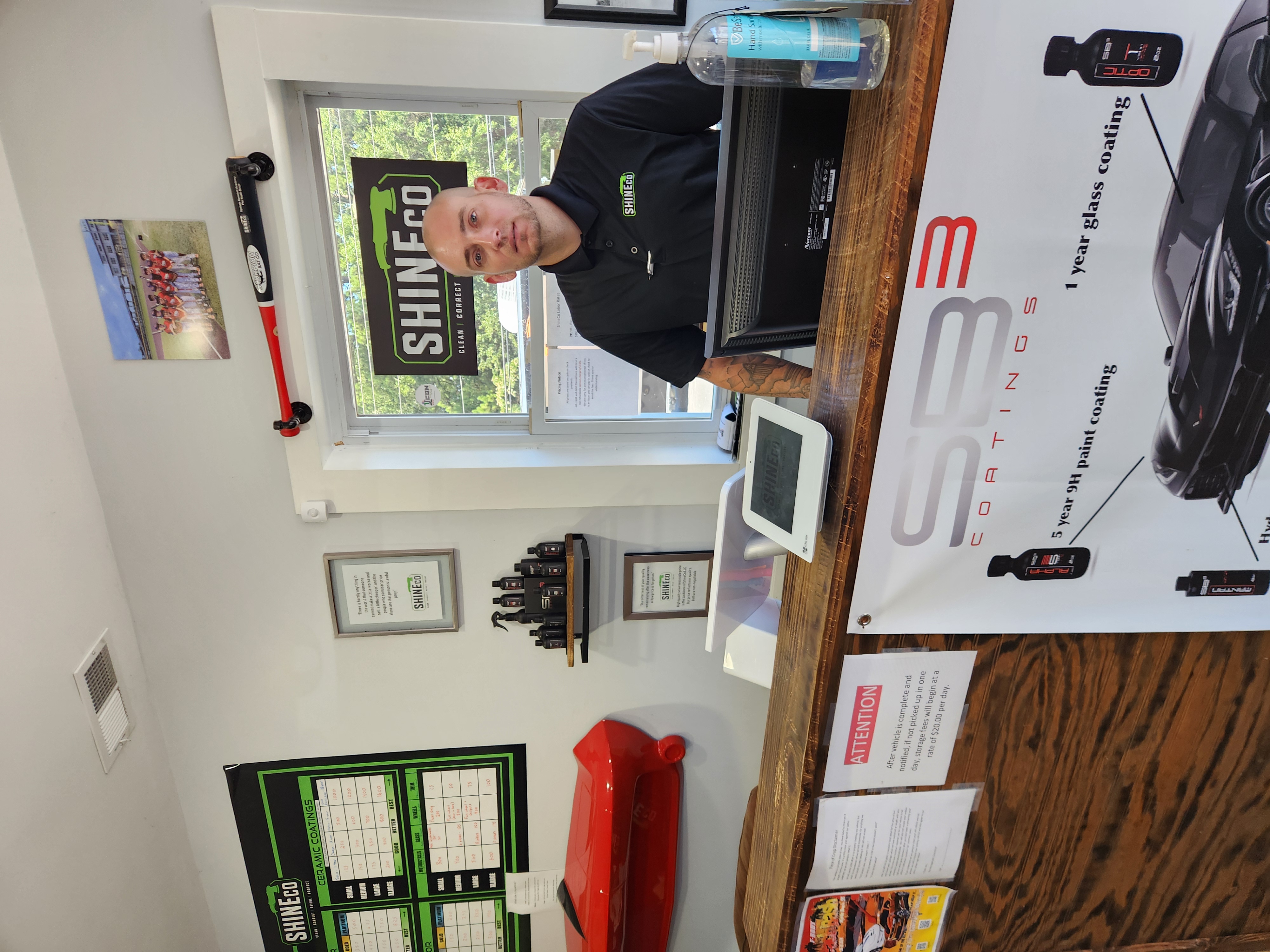 A man is standing in front of a sign that says shineco