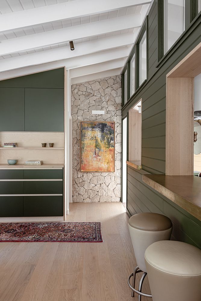 Interior with Green Cabinetry, Stone Wall, Artwork, Timber Bar, and Light-Coloured Stools — BSpoke Cabinet Making & Joinery in Unanderra, NSW