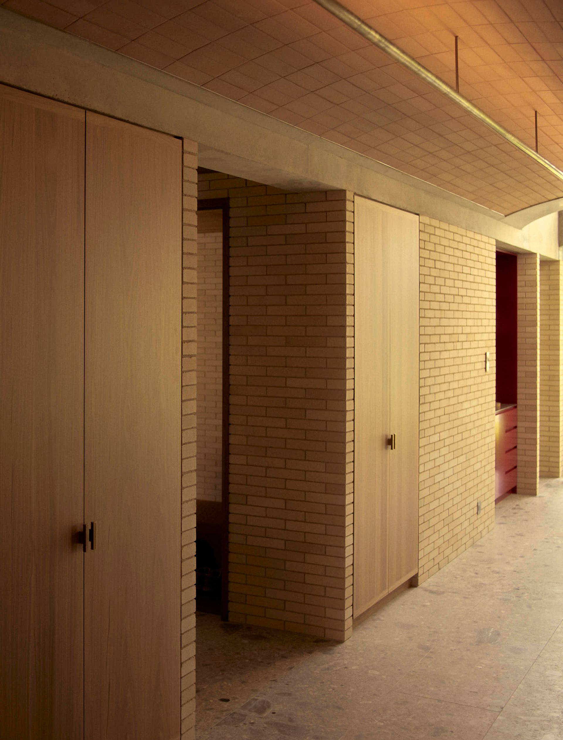 Corridor with wooden doors, brick walls, and arched brick ceiling. Concrete floor — BSpoke Cabinet Making & Joinery in Southerland Shire, NSW