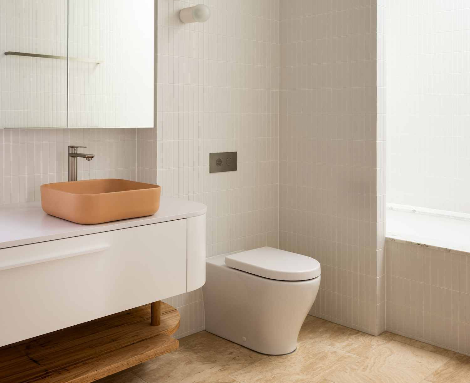 Modern bathroom with a white toilet, orange sink, and wood accents — BSpoke Cabinet Making & Joinery in Unanderra, NSW