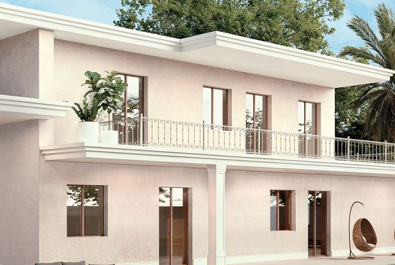 Edificio beige a due piani con balcone, ringhiere in vetro e ampie finestre