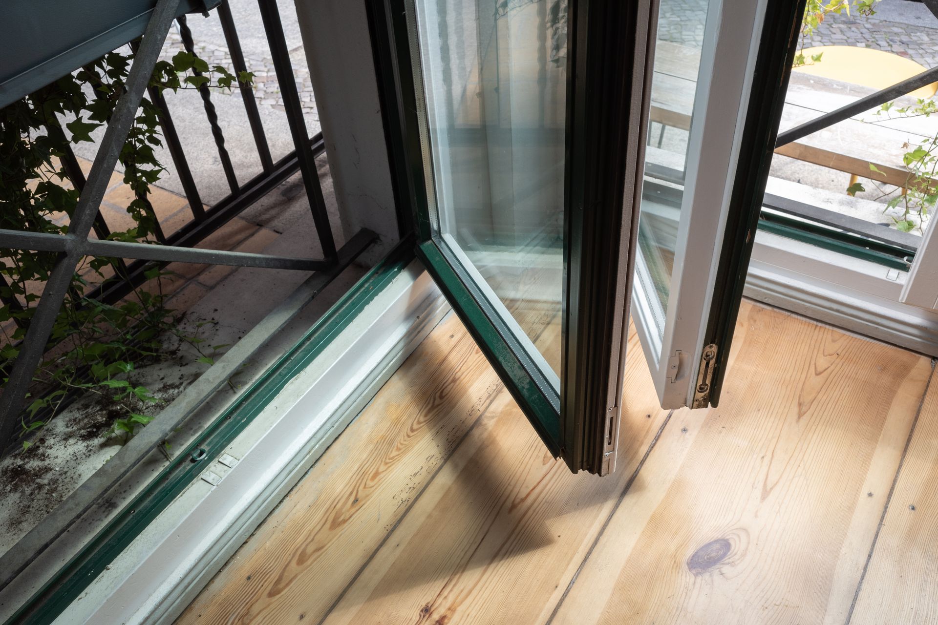 Open balcony door over wood floor, showing railing and outdoor walkway. — Kracken Windows and Doors In Dee Why, NSW