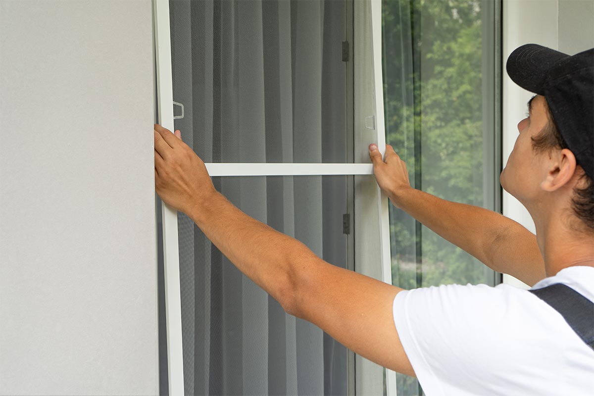 Handyman Installing A Fly Screen Into A Window