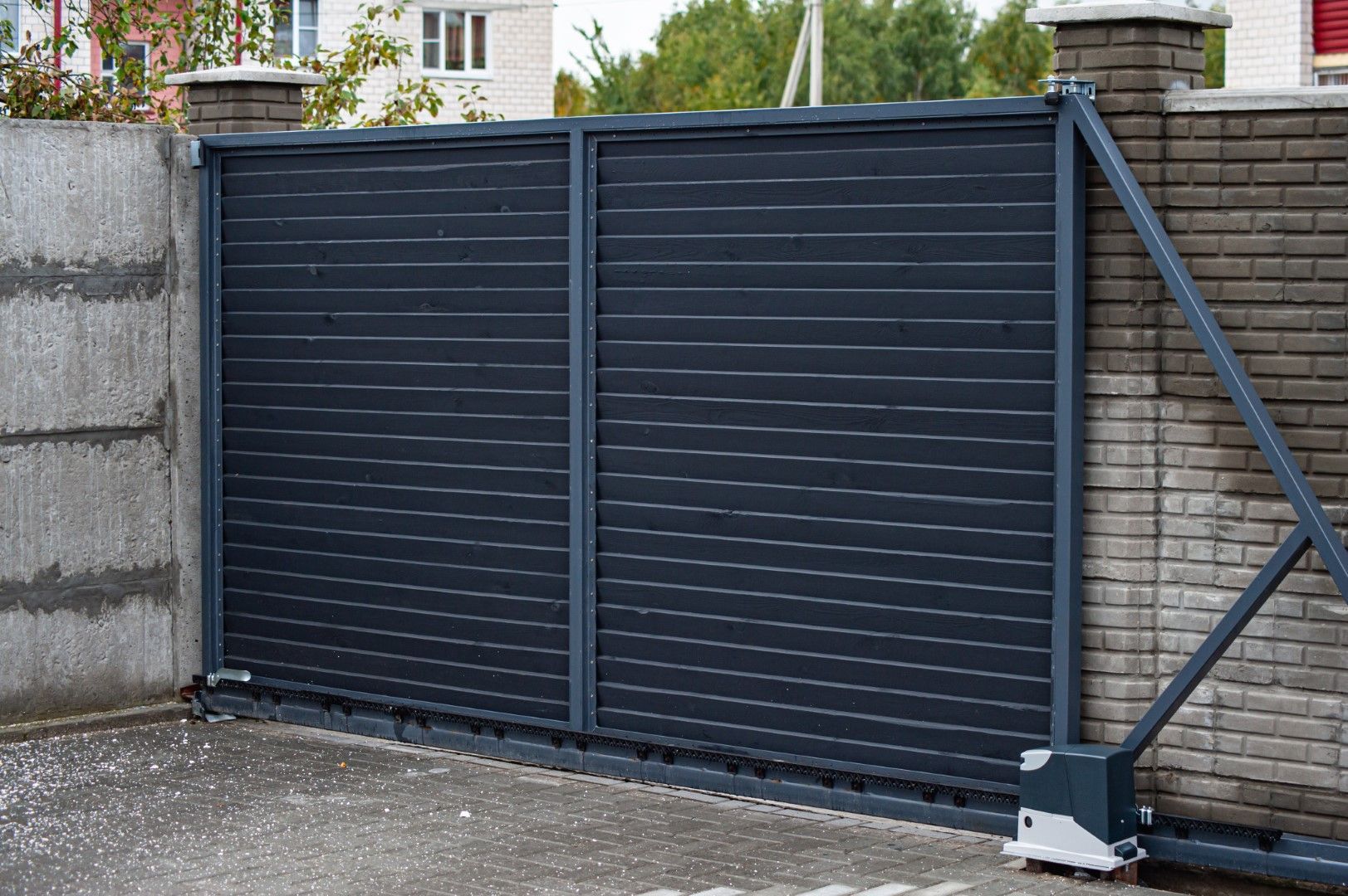 Dark gray horizontal sliding gate on concrete driveway.