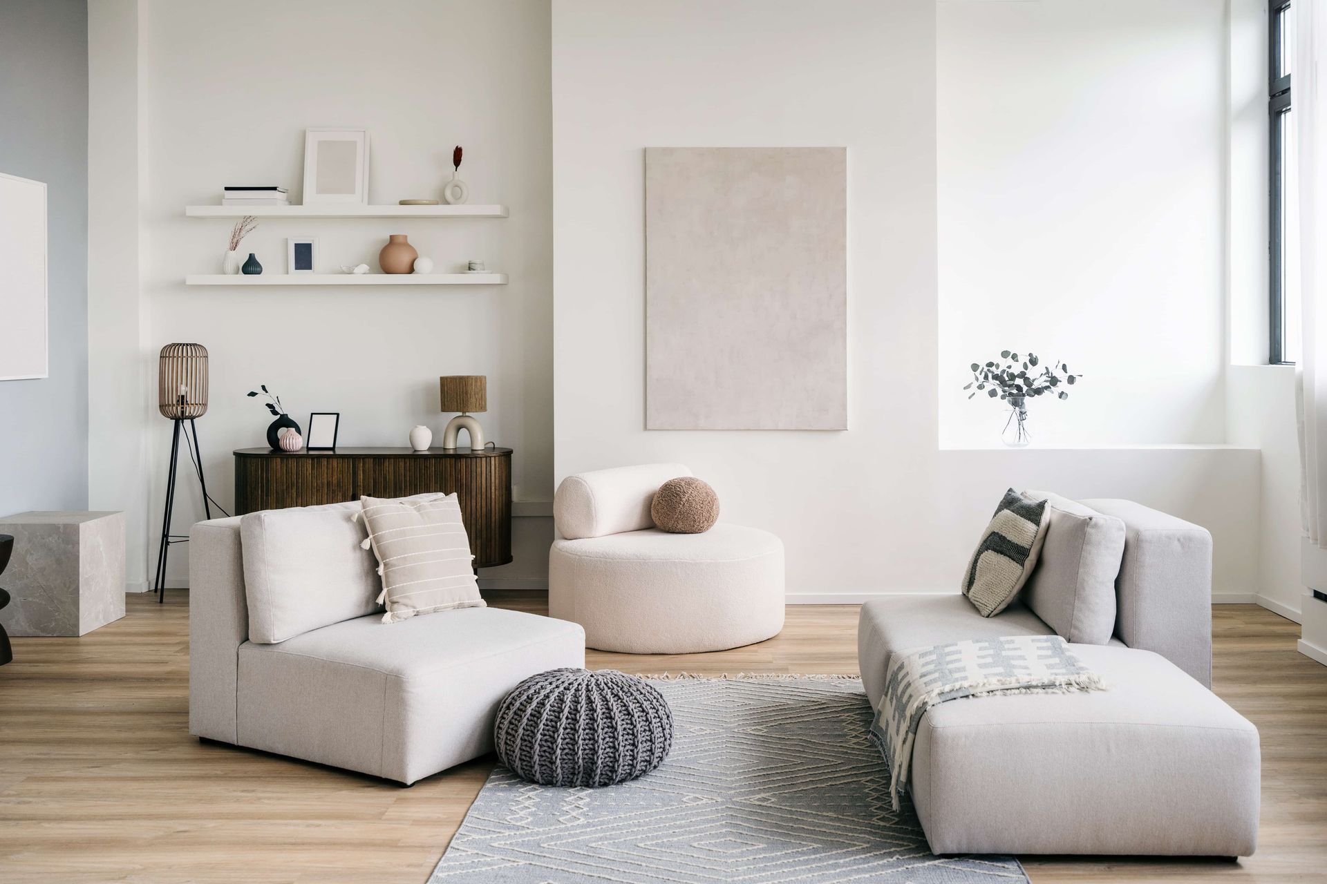 Modern living room with beige furniture, a rug, and decorative elements.