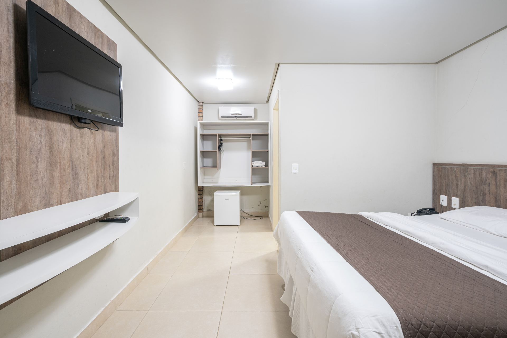 Um quarto de hotel com uma cama grande e uma TV de tela plana.