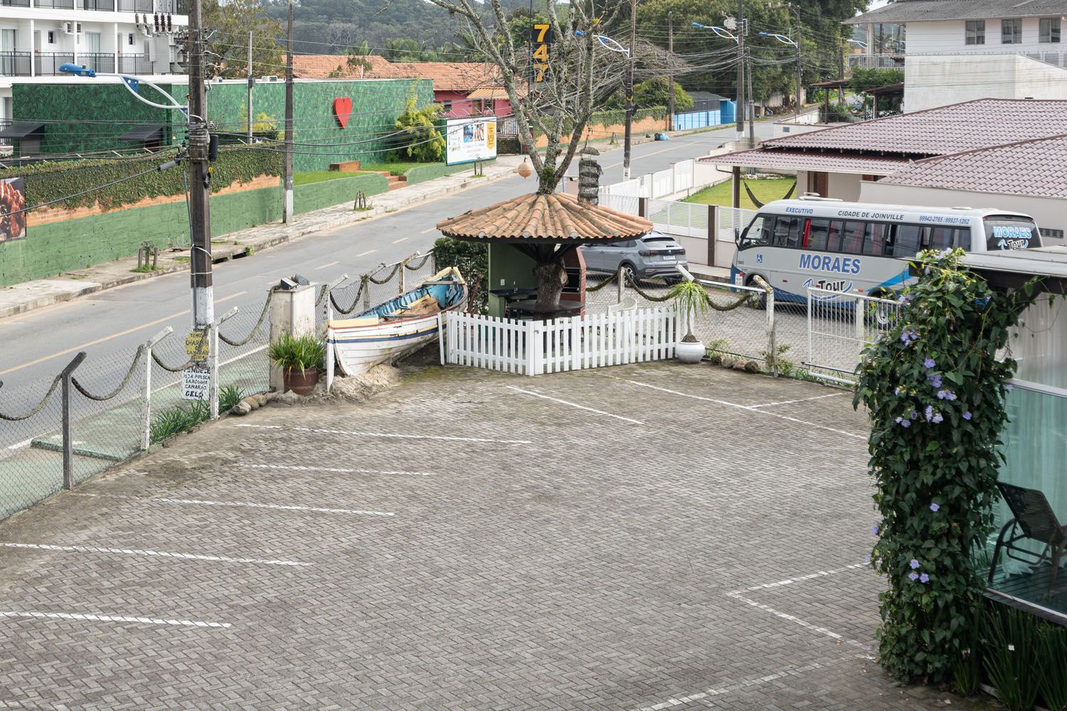 Um ônibus está estacionado em um estacionamento próximo a uma estrada.