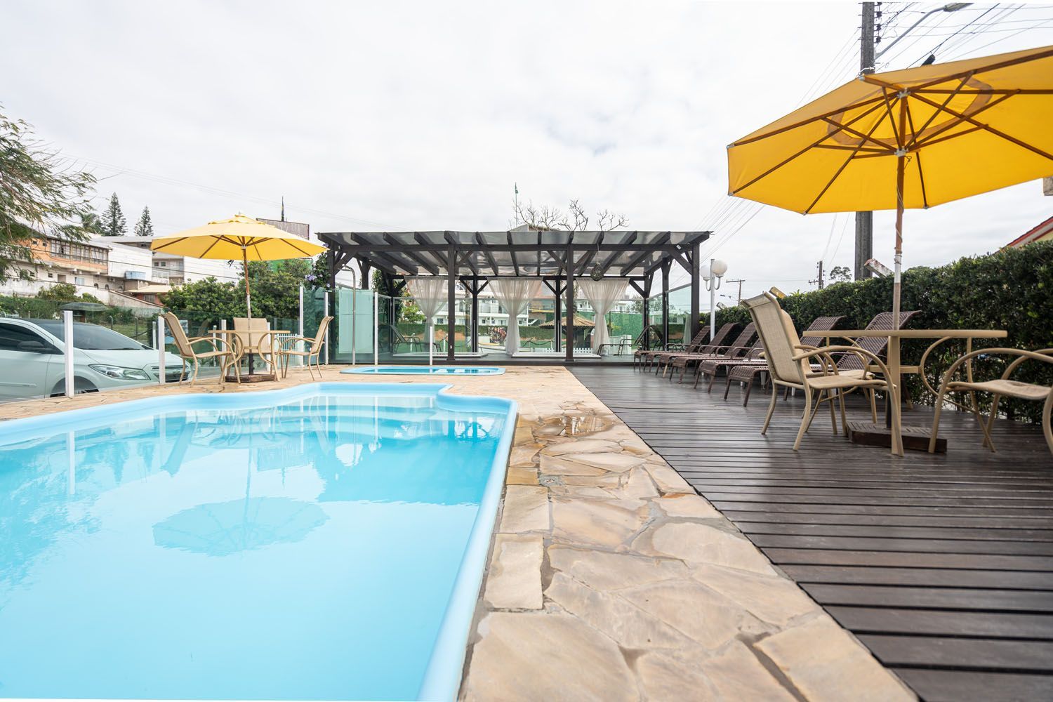 Uma grande piscina cercada por cadeiras e guarda-sóis.