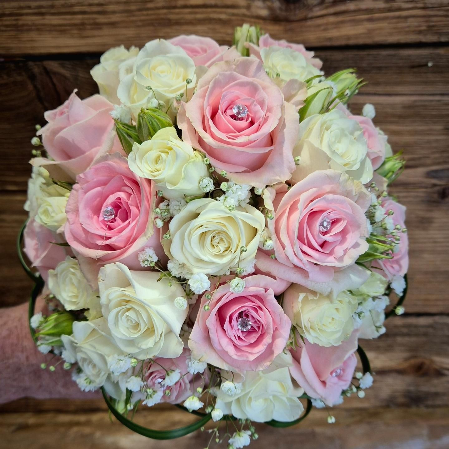 Bouquet di rose rosa e bianche su una superficie di legno
