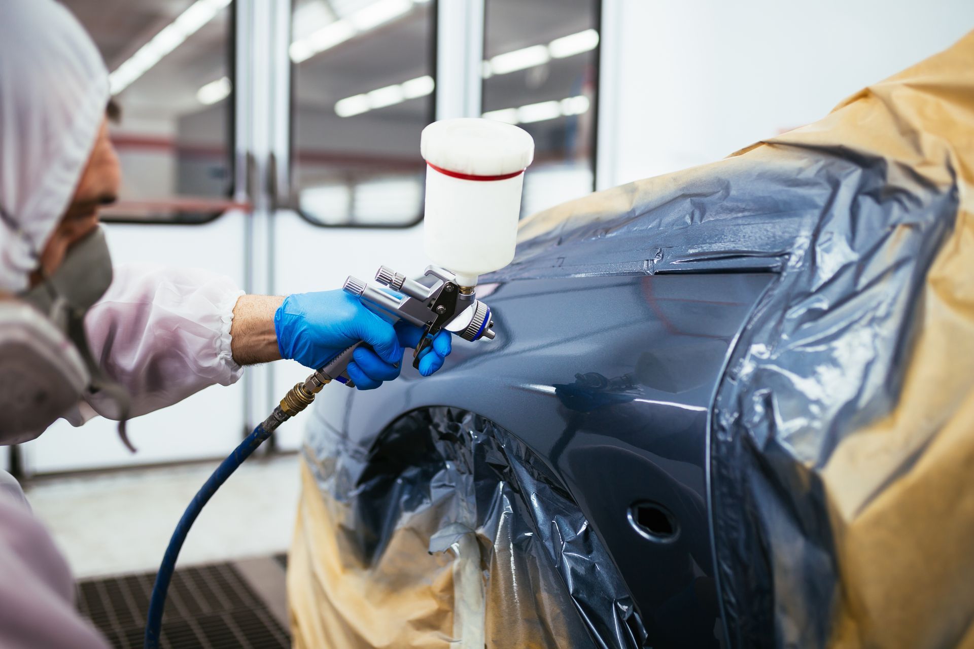 Car panel being spray-painted