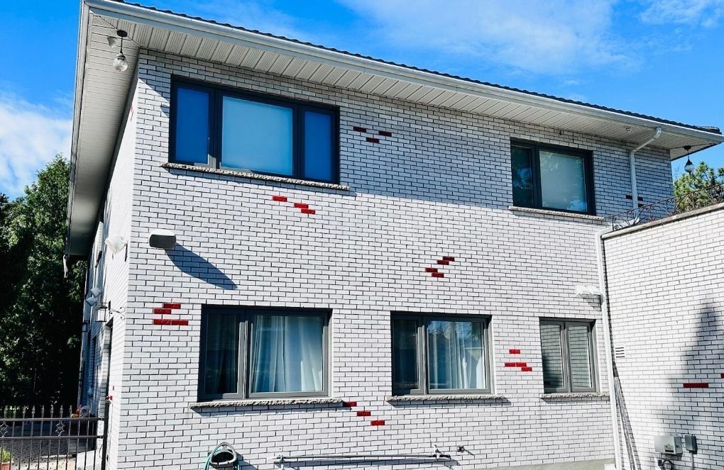 Une maison en briques blanches avec un ciel bleu en arrière-plan