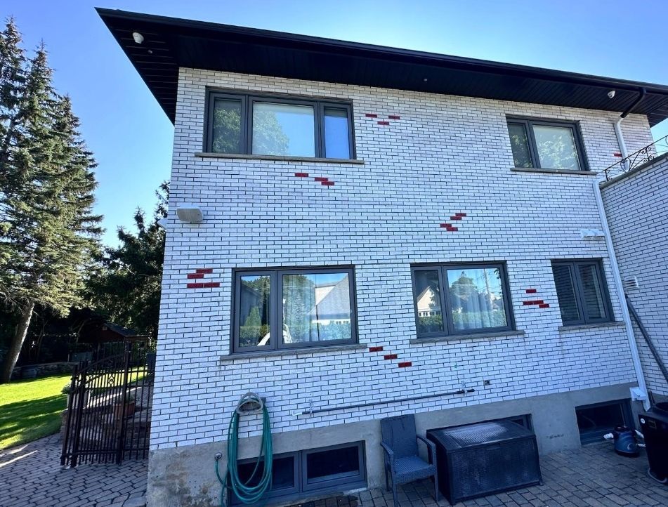 Une grande maison en briques blanches avec beaucoup de fenêtres