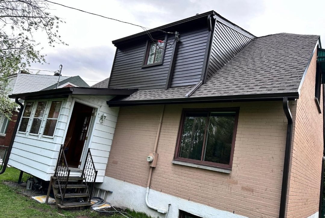 Une maison avec un toit en pente et des escaliers dans l'arrière-cour.