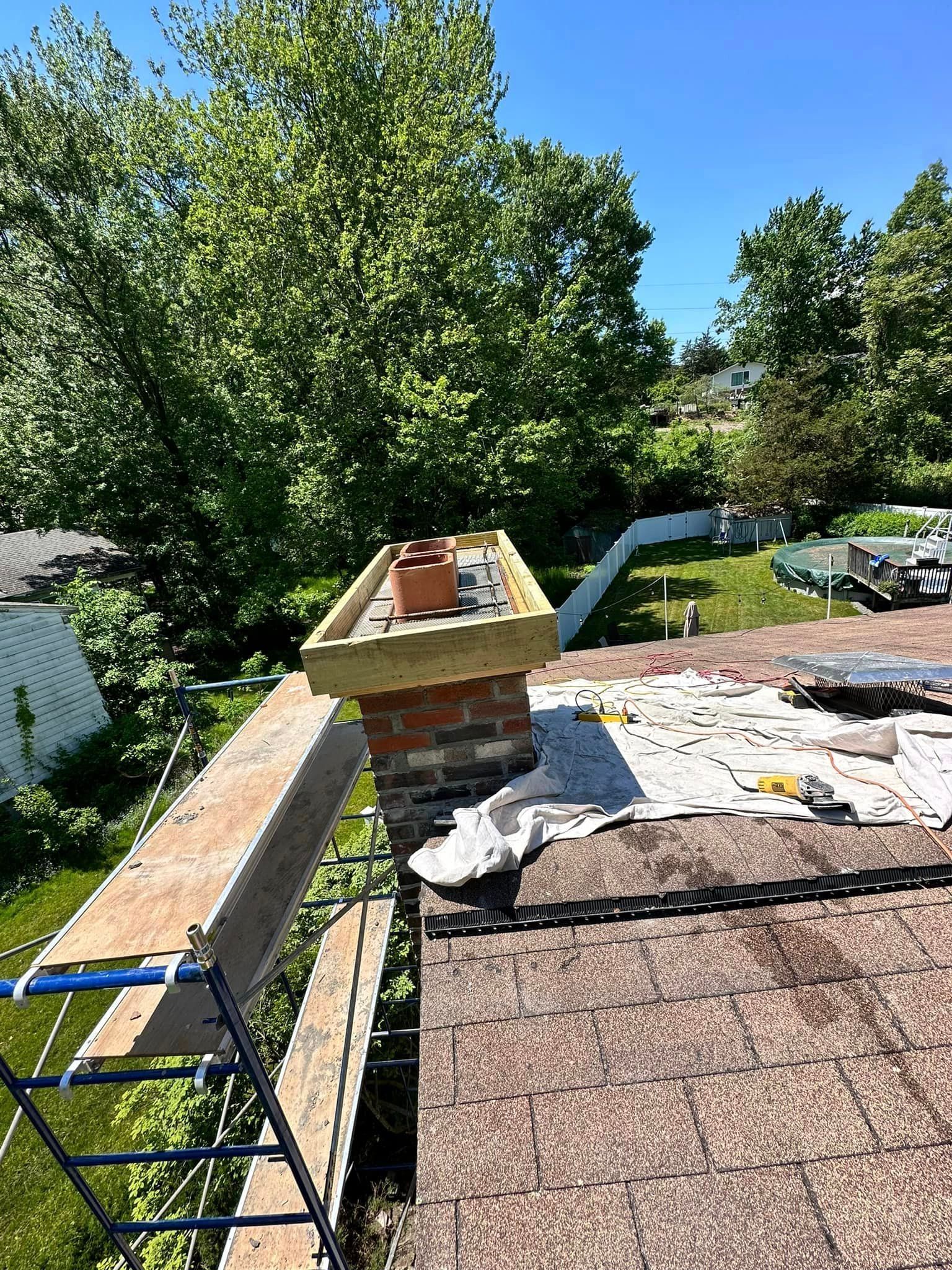 A brick chimney is sitting on top of a roof.