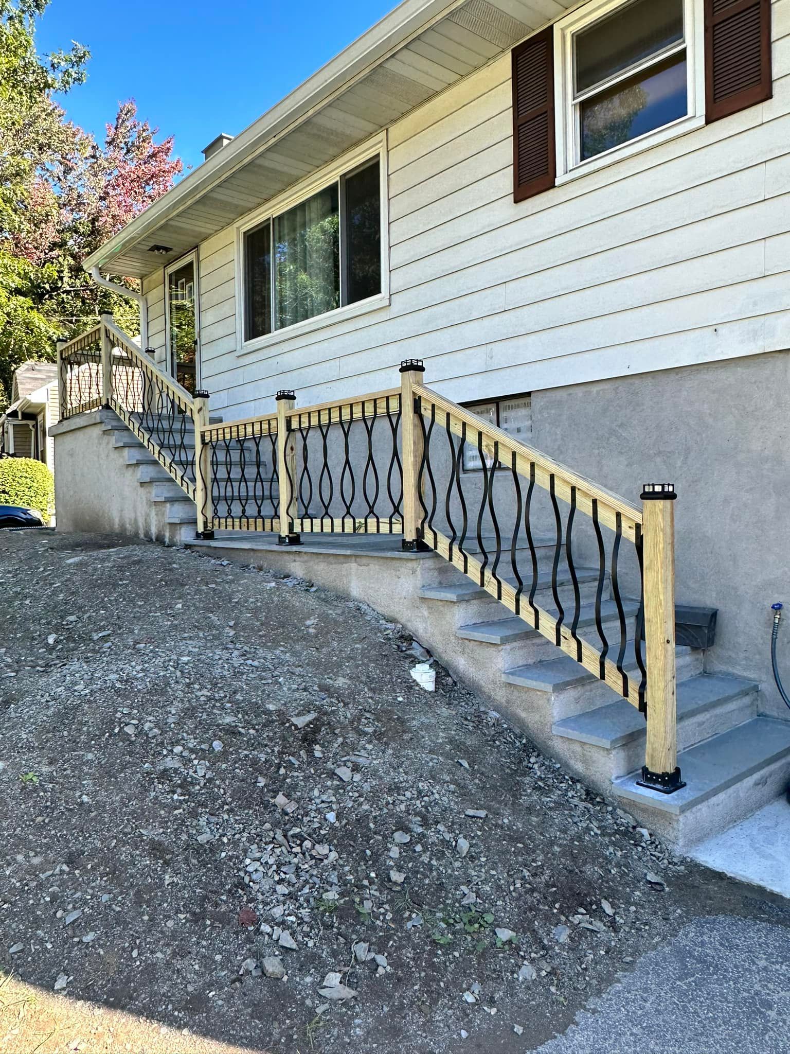 A house with stairs leading up to it and a wooden railing.