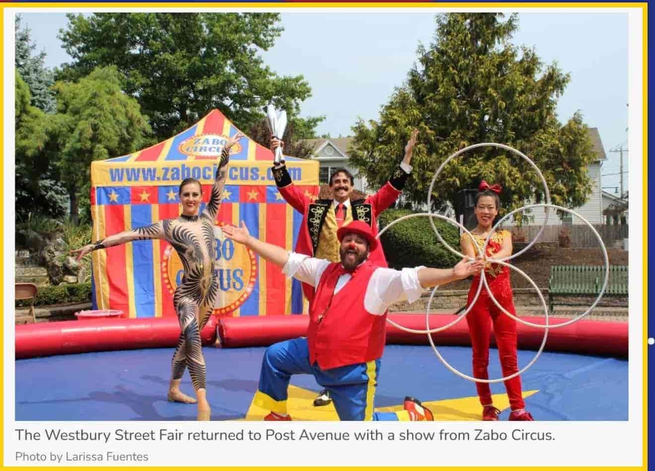 A group of people are posing for a picture in front of a circus tent.