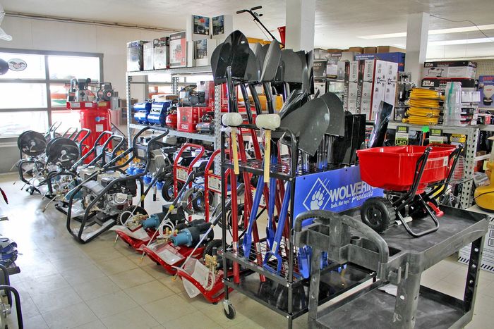 Busy bike shop with rows of bicycles and repair stands, including a red workbench in the foreground