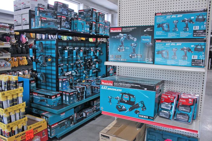 A store display of blue and black toy tools and construction playsets on shelves and pallets.