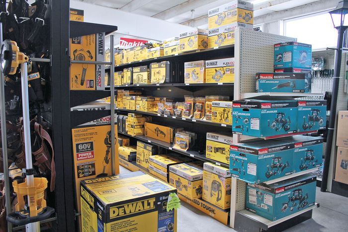 Hardware store aisle stacked with yellow and blue DEWALT tool boxes and power tools