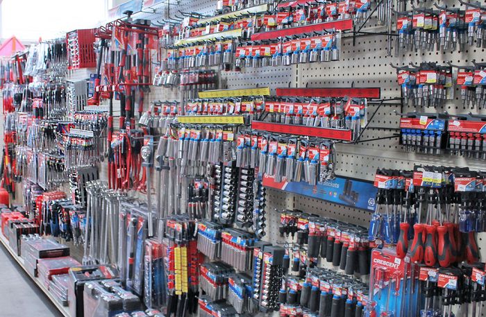 Store aisle with rows of hanging hardware tools and accessories on pegboard displays
