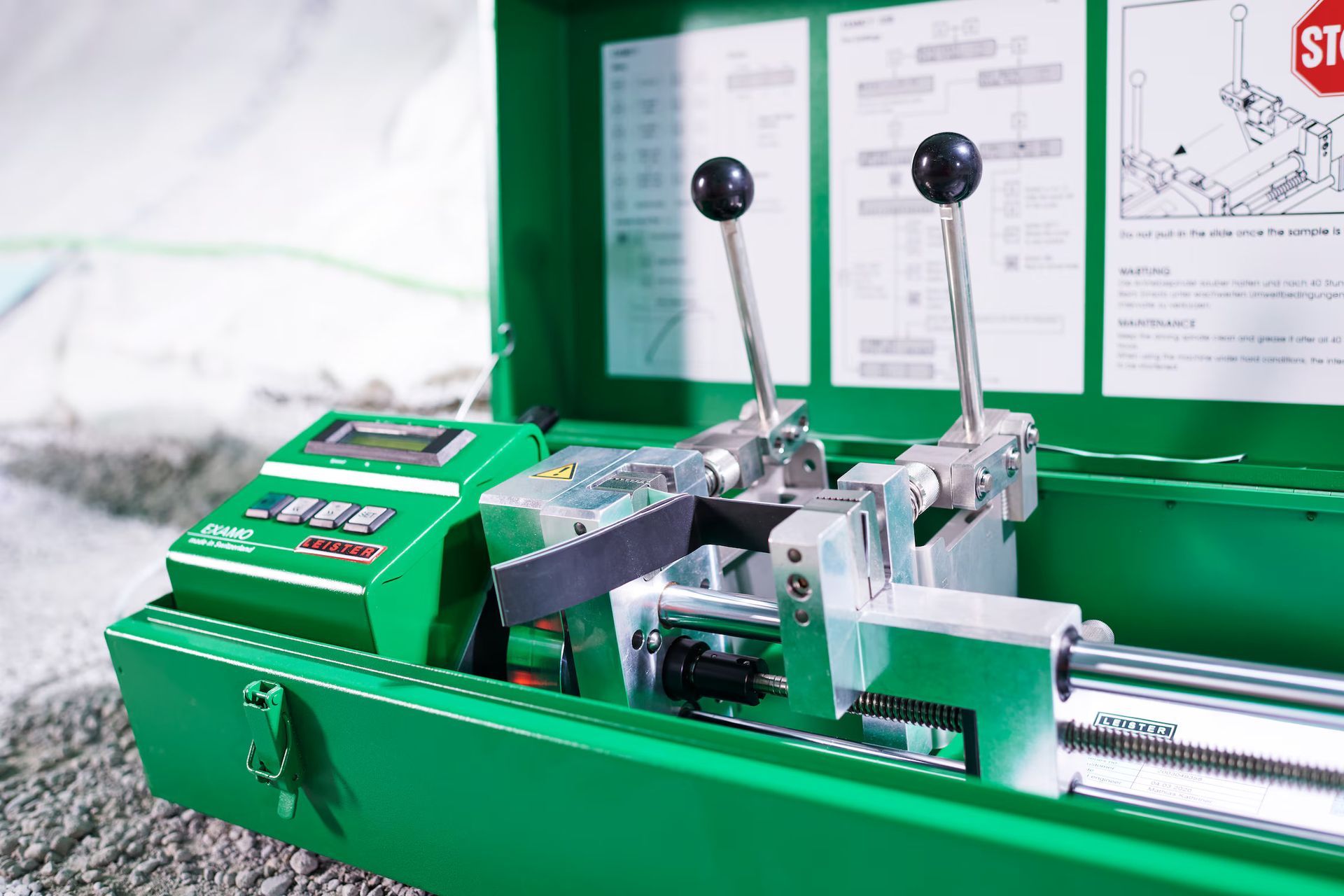 Green pipe fusion machine in open case with levers and digital display.
