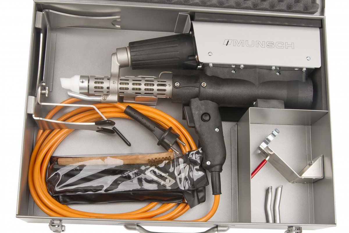 A metal case containing a black and silver plastic welding tool, orange hose, and accessories.
