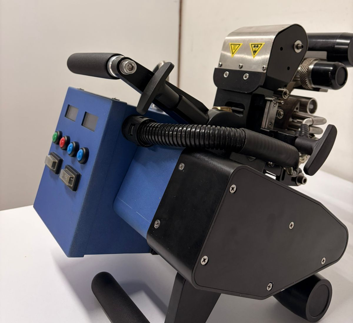 Blue and black robotic device with hoses and controls, mounted on a stand in a lab setting
