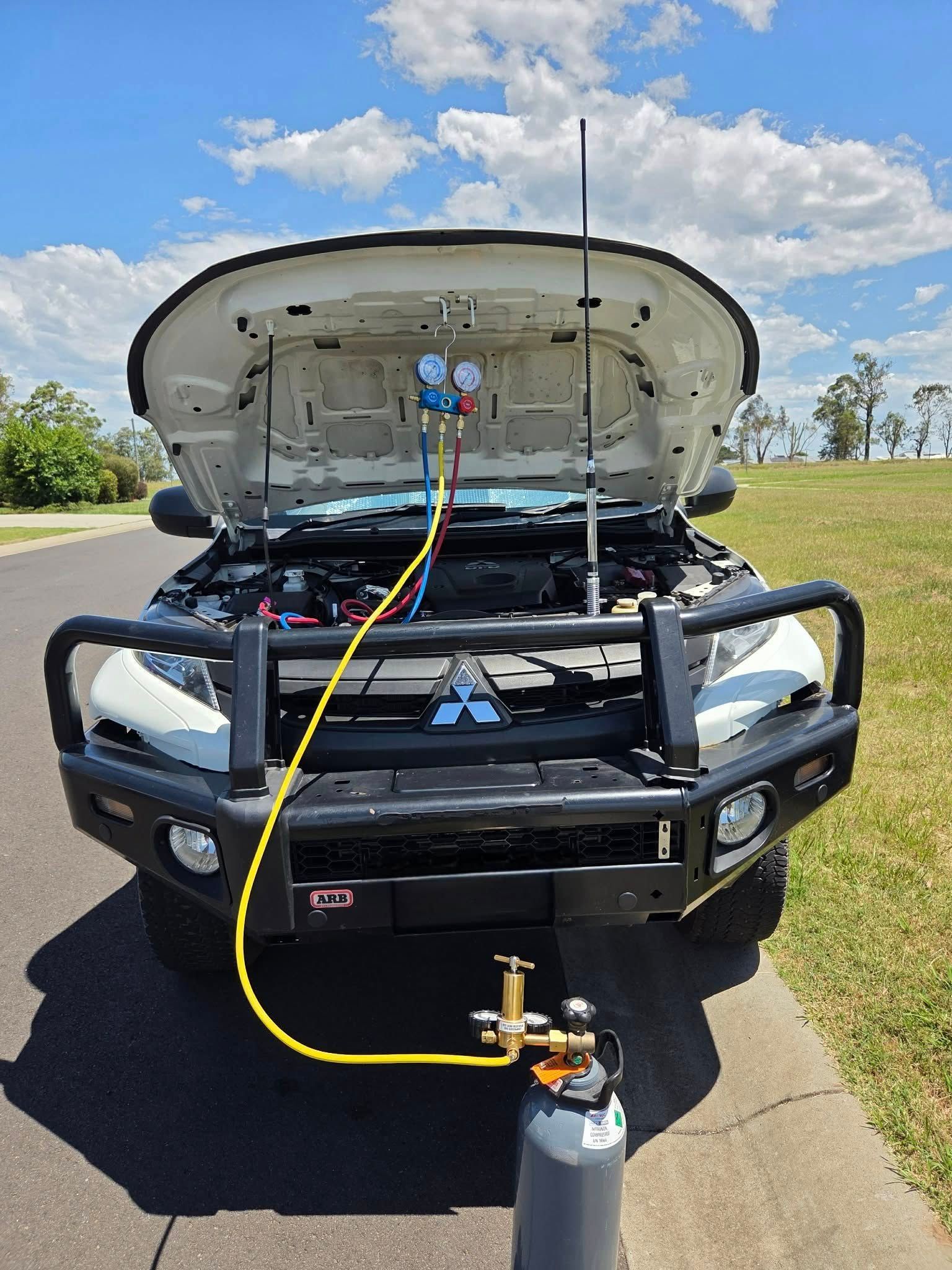A Car with An Open Hood Connected to A Pressure Gauge Manifold — Exceed Onsite Mechanical in Grafton, NSW