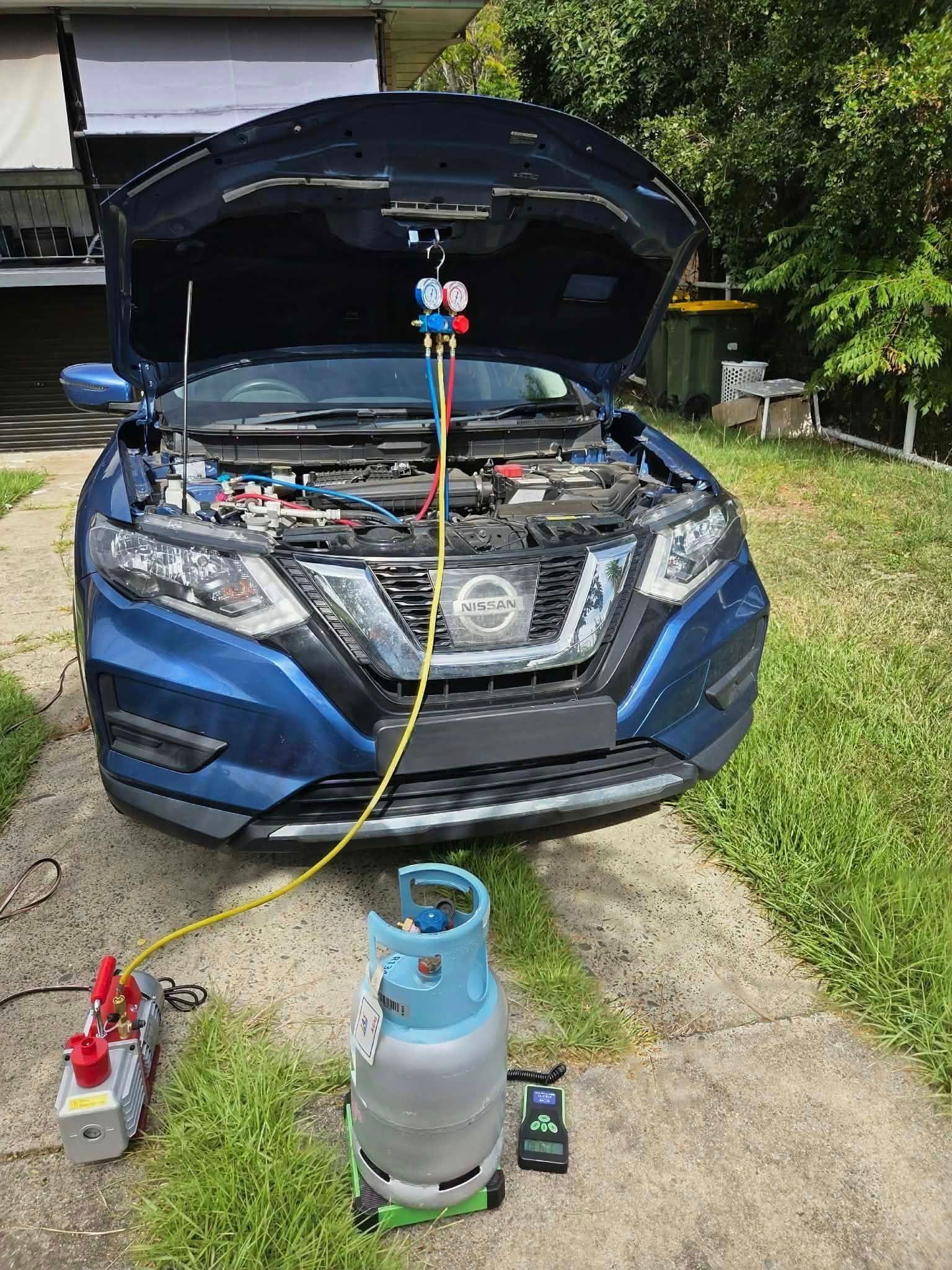 A Blue Nissan SUV with Its Hood Open, Connected to A Refrigerant Recovery Tank — Exceed Onsite Mechanical in Grafton, NSW