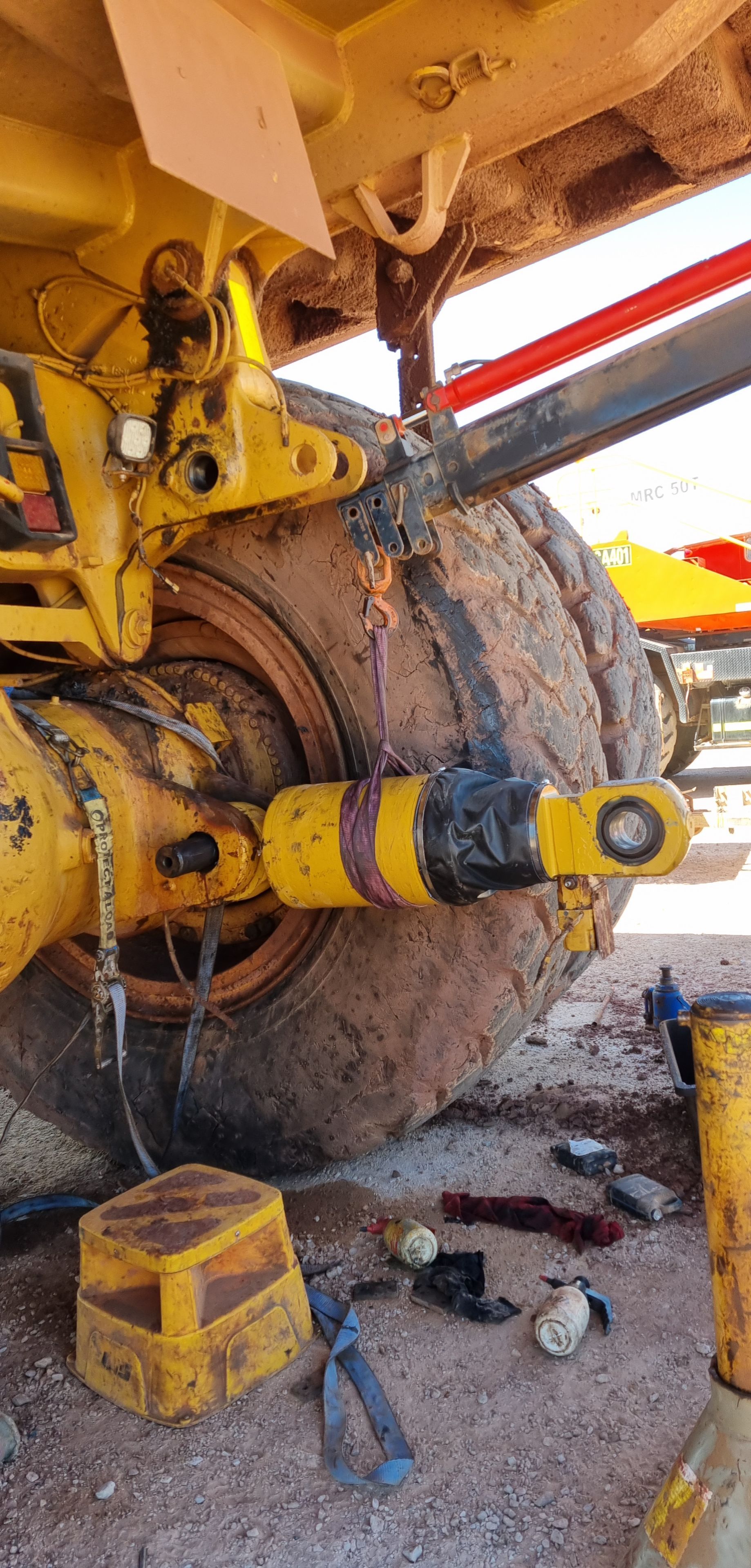 A large, yellow heavy-duty vehicle with a dual-tire assembly, showing mechanical repair work near the axle and wheel hub — Exceed Onsite Mechanical in Grafton, NSW