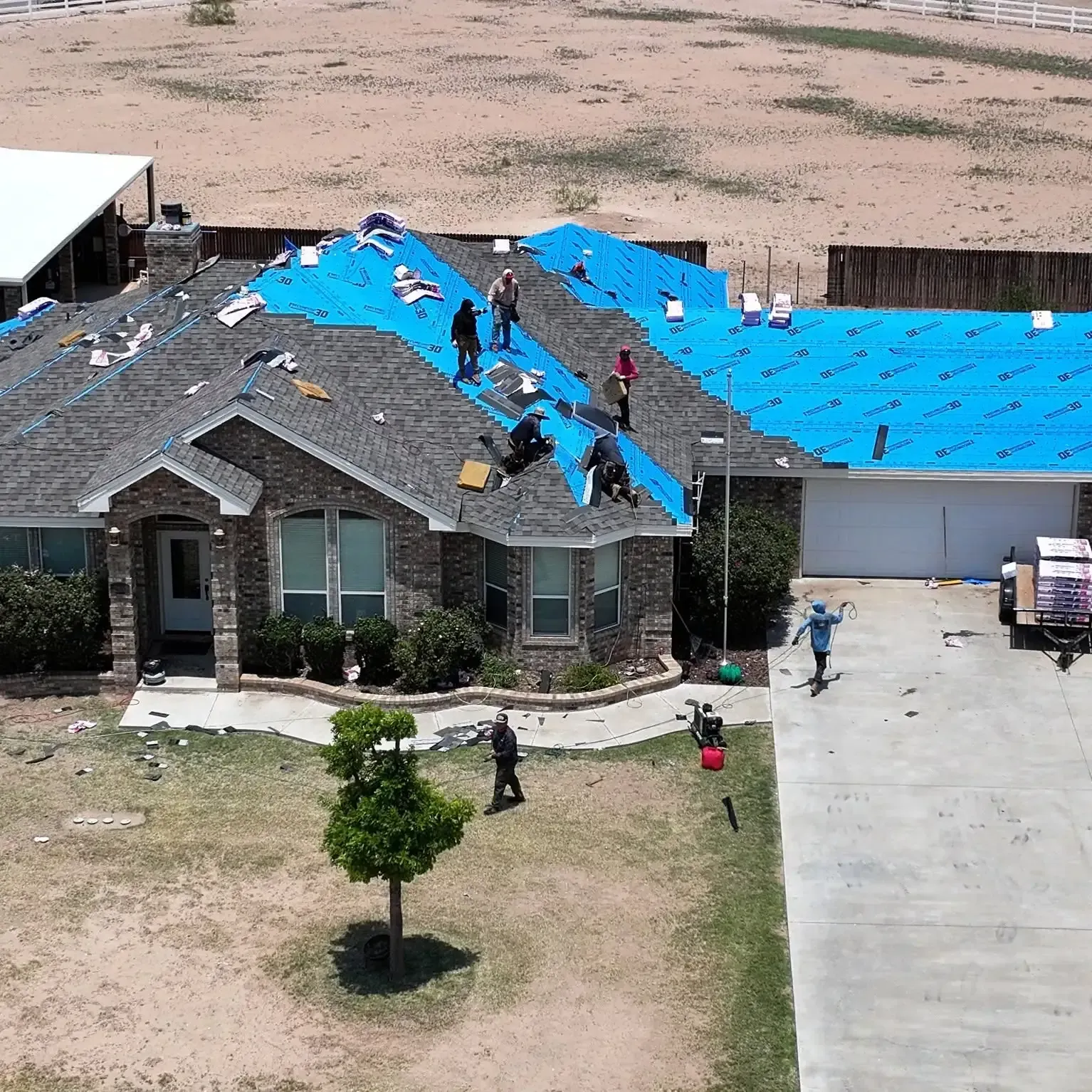 Roofs by Nicholas crew installing a new shingle roof on a brick home in Midland, TX