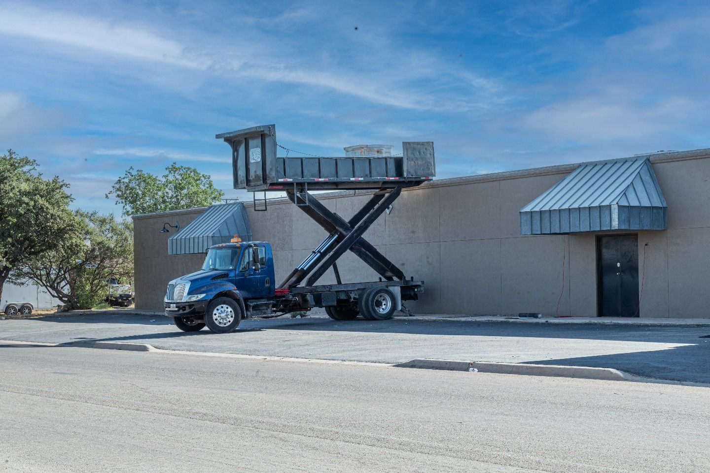 Roofing truck with hydraulic lift delivering materials to the commercial building roof