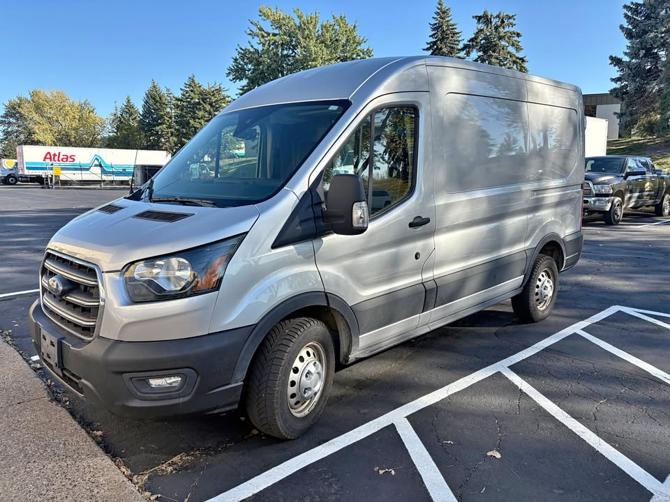 Silver Ford Transit van parked in a parking lot.