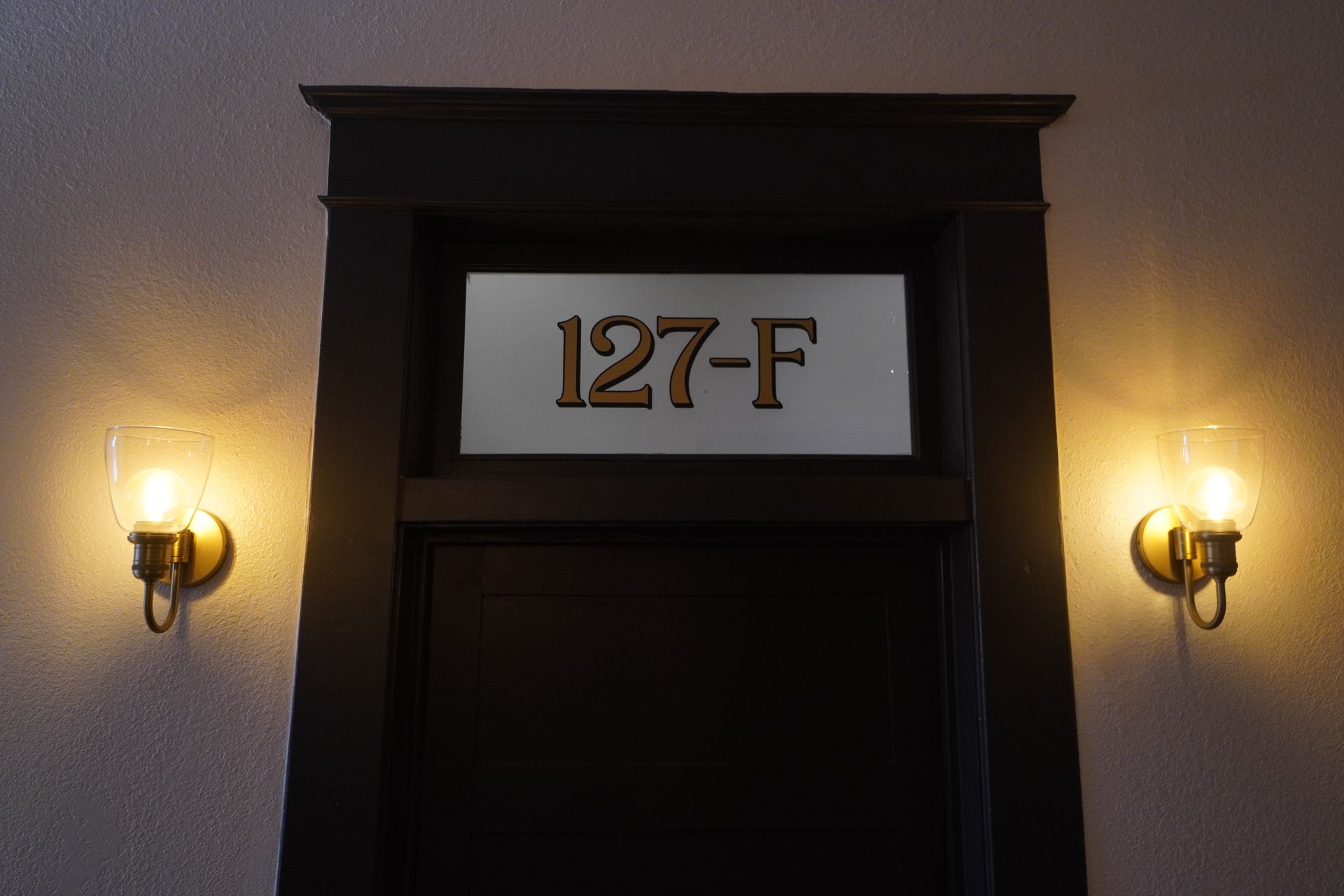 Black door with illuminated sign 