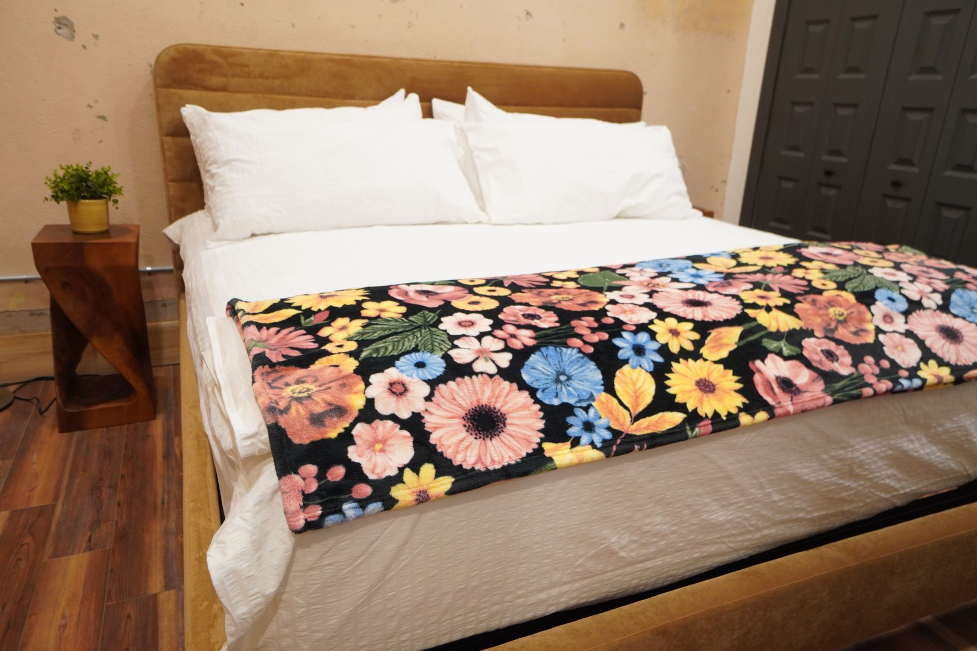 Bedroom with a bed, nightstand, and a floral blanket.