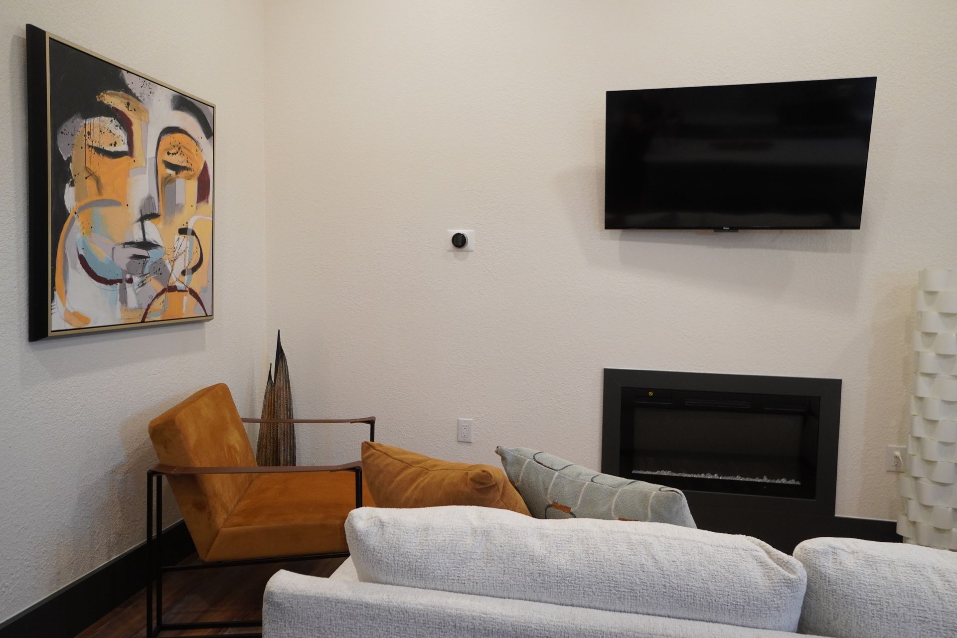 Living room with artwork, TV, fireplace, and seating.