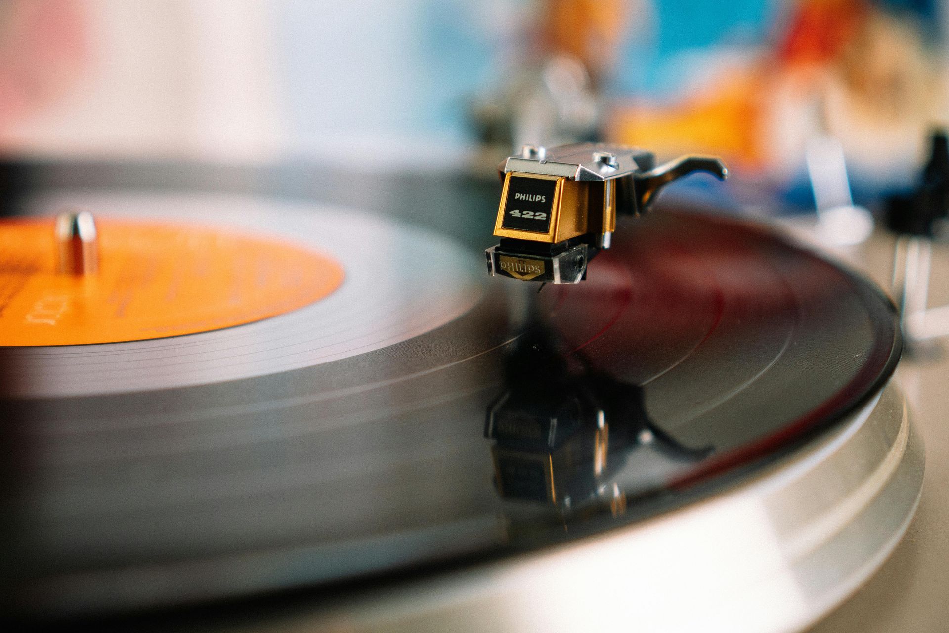 Close-up of a vinyl record spinning on a turntable with a stylus on the groove.
